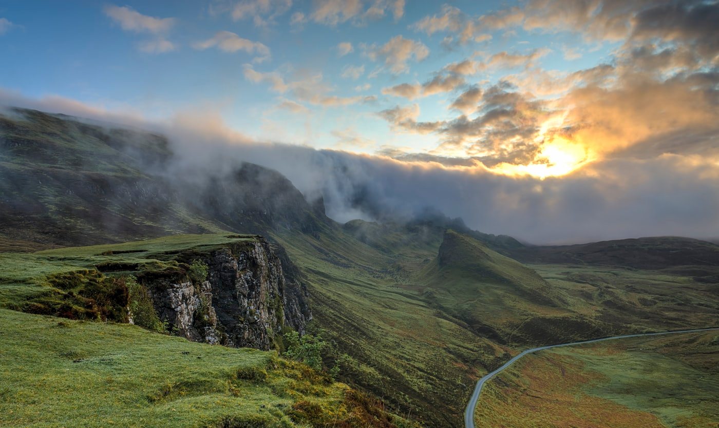 Mist lifting over rolling hills at first light